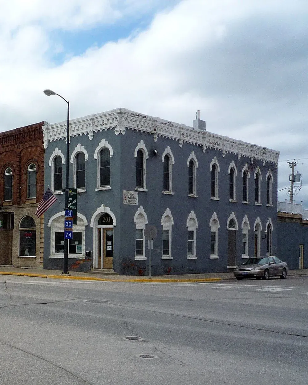 A row of historic brick storefronts, including a tall blue Italianate corner building, along Main Street in downtown Chatfield, Minnesota.