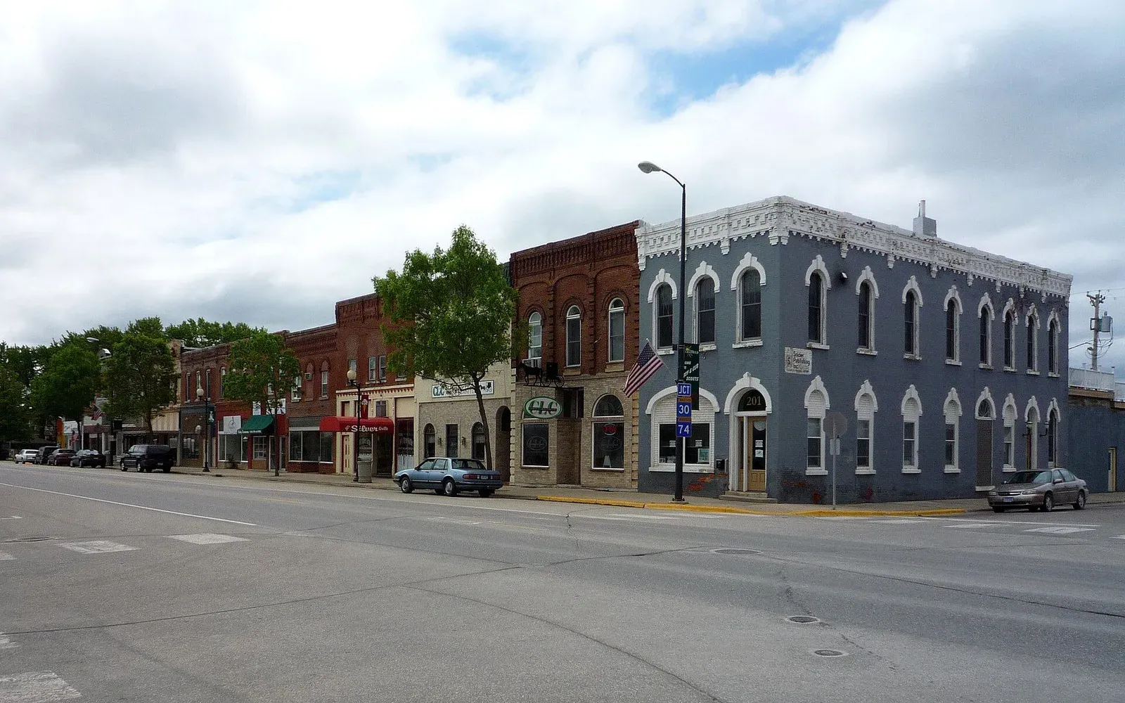 A row of historic brick storefronts, including a tall blue Italianate corner building, along Main Street in downtown Chatfield, Minnesota.
