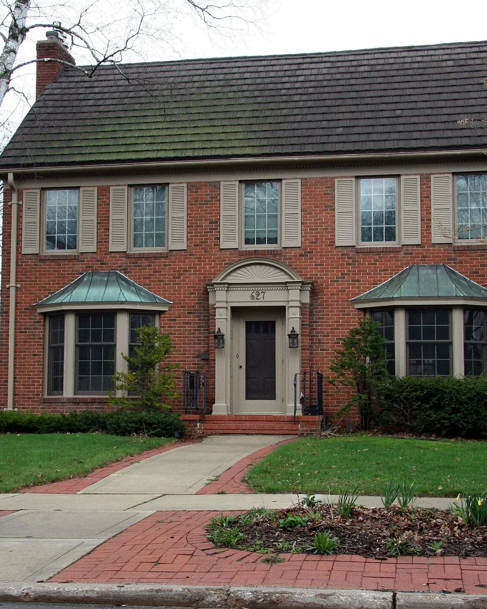 A ranch-style home with a deep front yard on a residential street in the Greenview neighborhood of south Rochester.