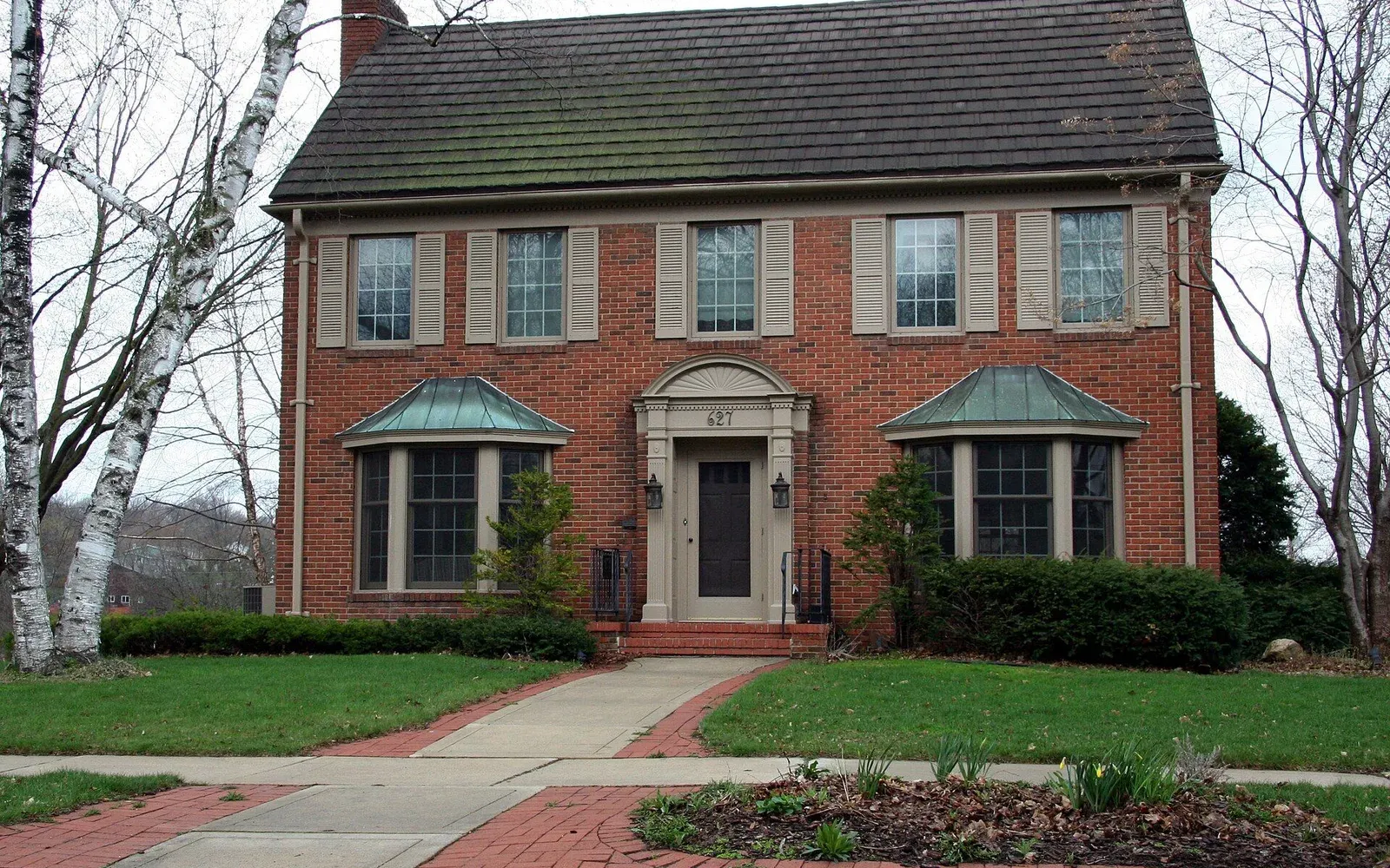 A ranch-style home with a deep front yard on a residential street in the Greenview neighborhood of south Rochester.