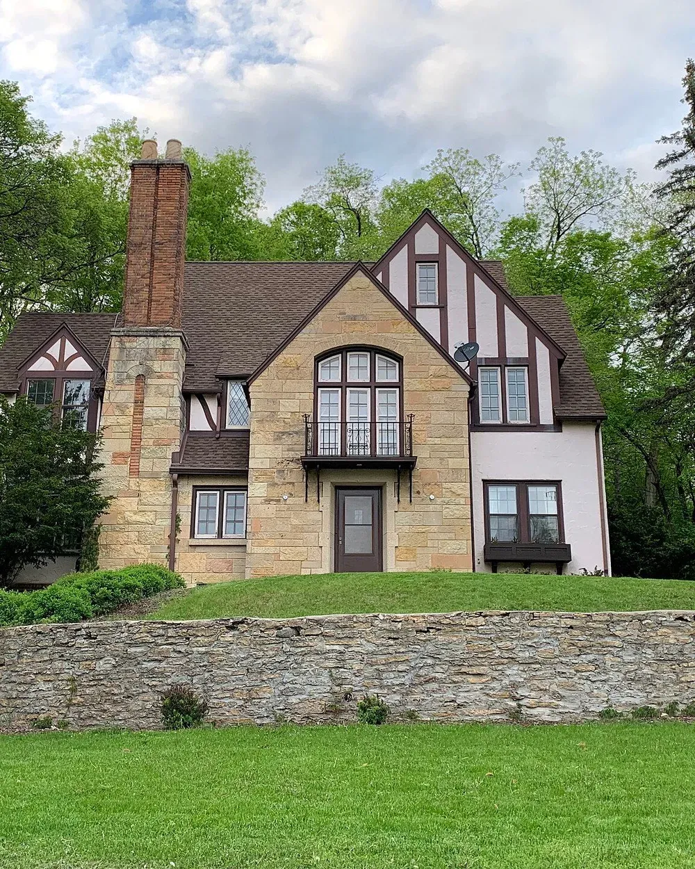A two-story Tudor-style home with a side addition in the Historic Southwest neighborhood of Rochester, Minnesota.