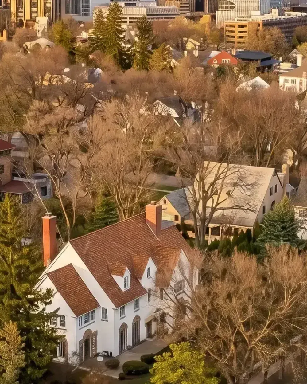 Aerial view of the Pill Hill Historic Landmark District in Rochester, Minnesota, with downtown and the Mayo Clinic skyline in the background at sunset.