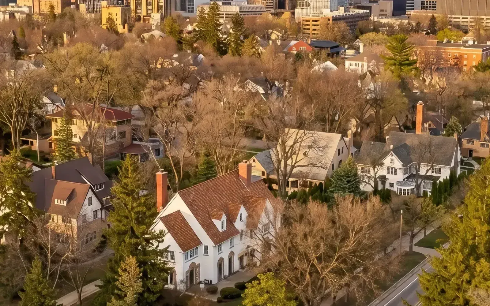 Aerial view of the Pill Hill Historic Landmark District in Rochester, Minnesota, with downtown and the Mayo Clinic skyline in the background at sunset.