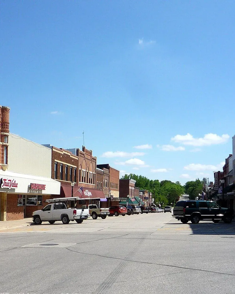 A view down a downtown street in Spring Valley, Minnesota, with historic brick storefronts under a summer sky.