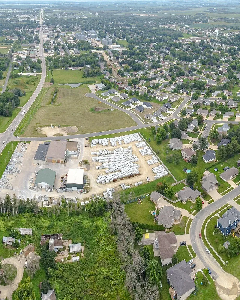 An aerial view of Stewartville, Minnesota, looking across newer residential subdivisions toward the older downtown core in the distance.