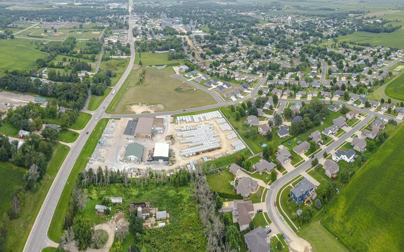 An aerial view of Stewartville, Minnesota, looking across newer residential subdivisions toward the older downtown core in the distance.