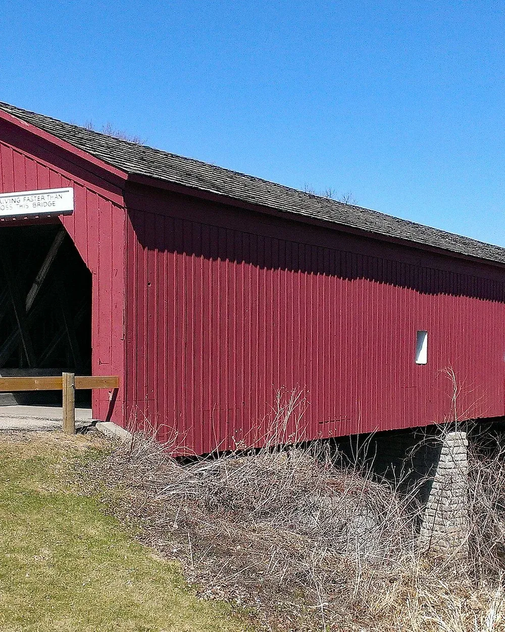 The Zumbrota covered bridge, the last historic covered bridge in Minnesota, seen across a snowy Covered Bridge Park in winter.